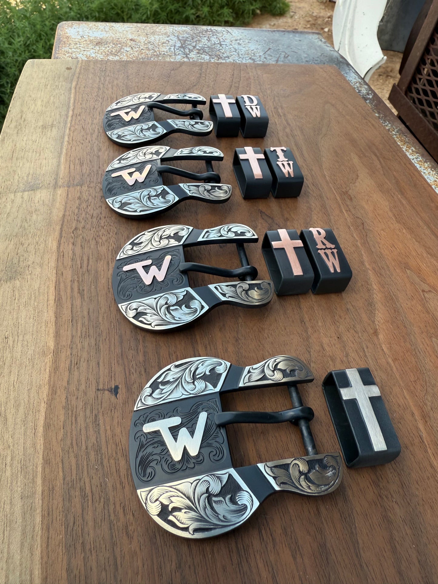 4 1 inch belt buckles on wood background