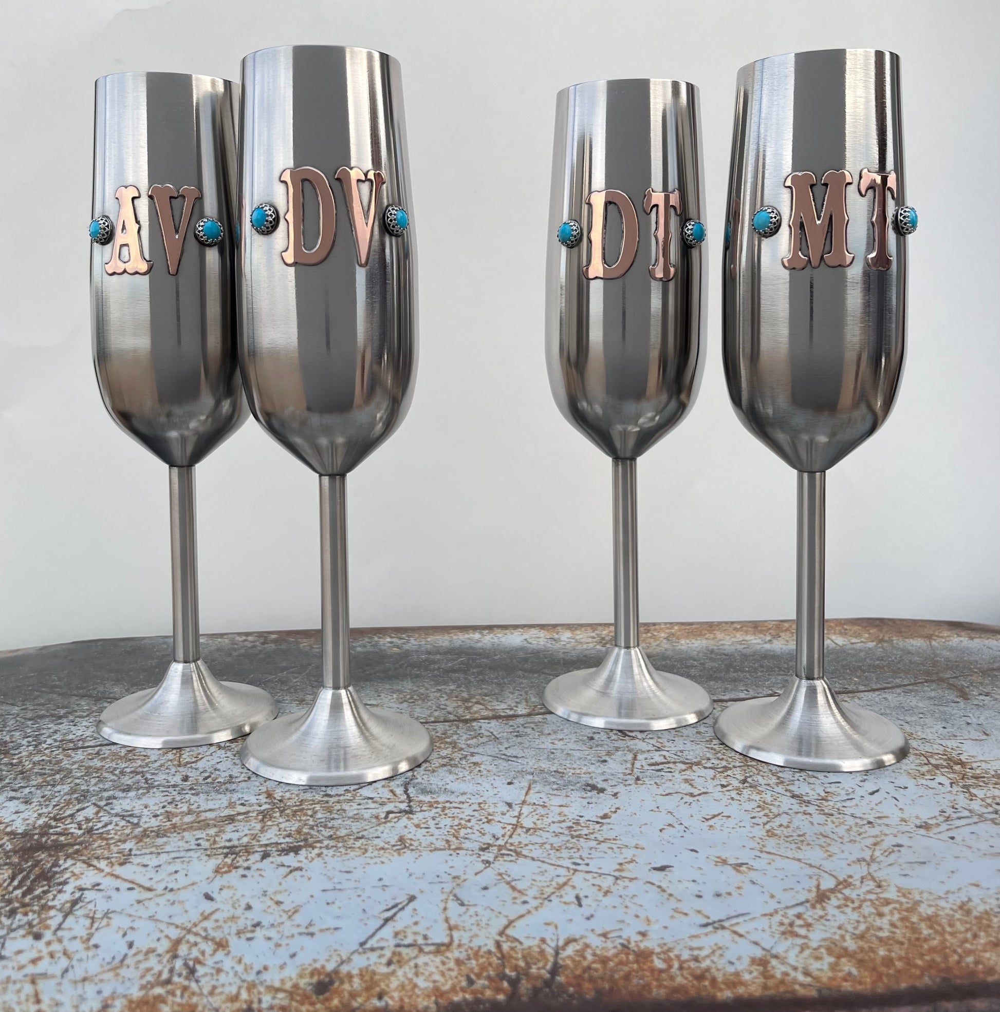 two sets of wedding champagne flutes with initials and turquoise