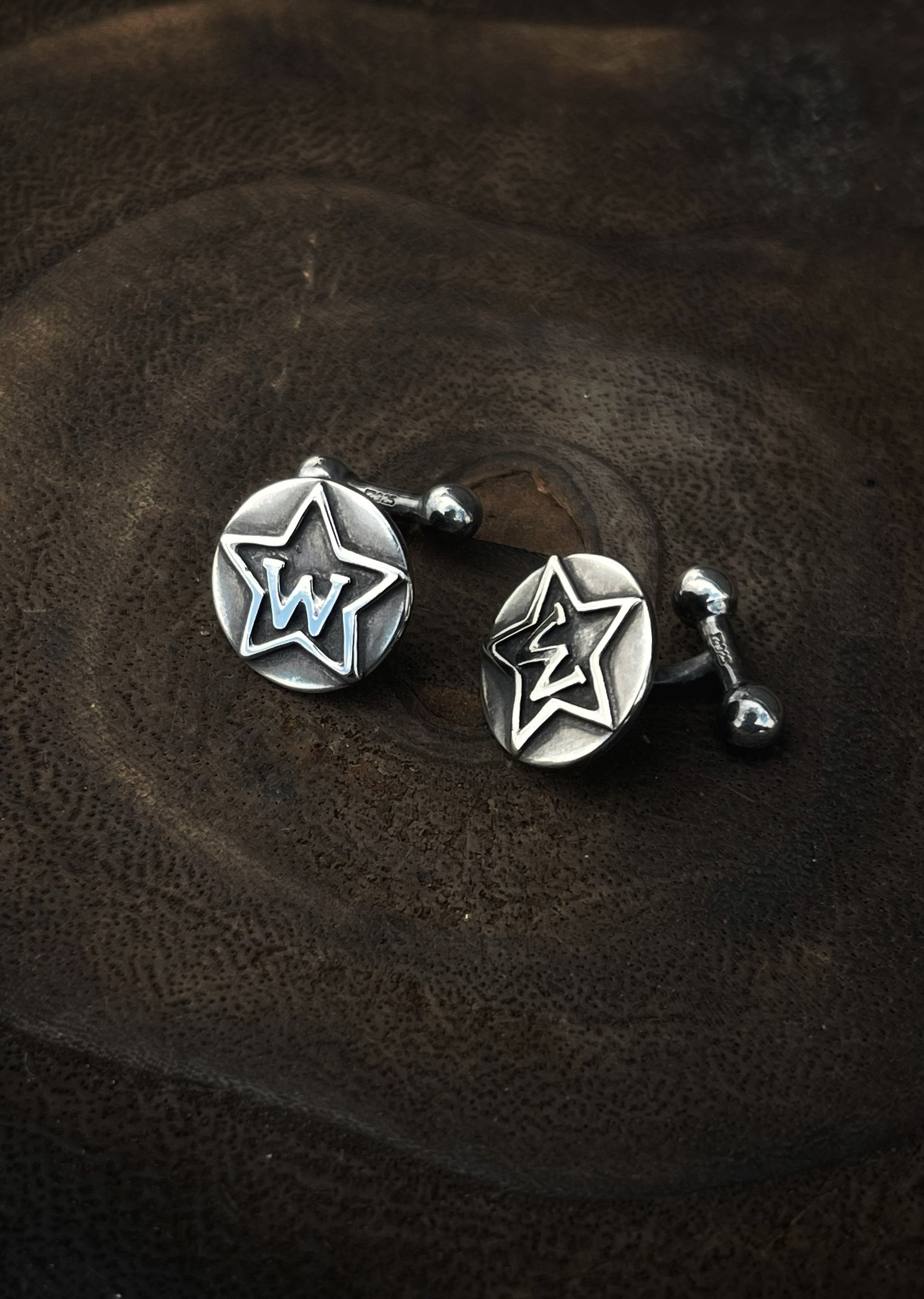 Sterling silver cufflinks on a wood background